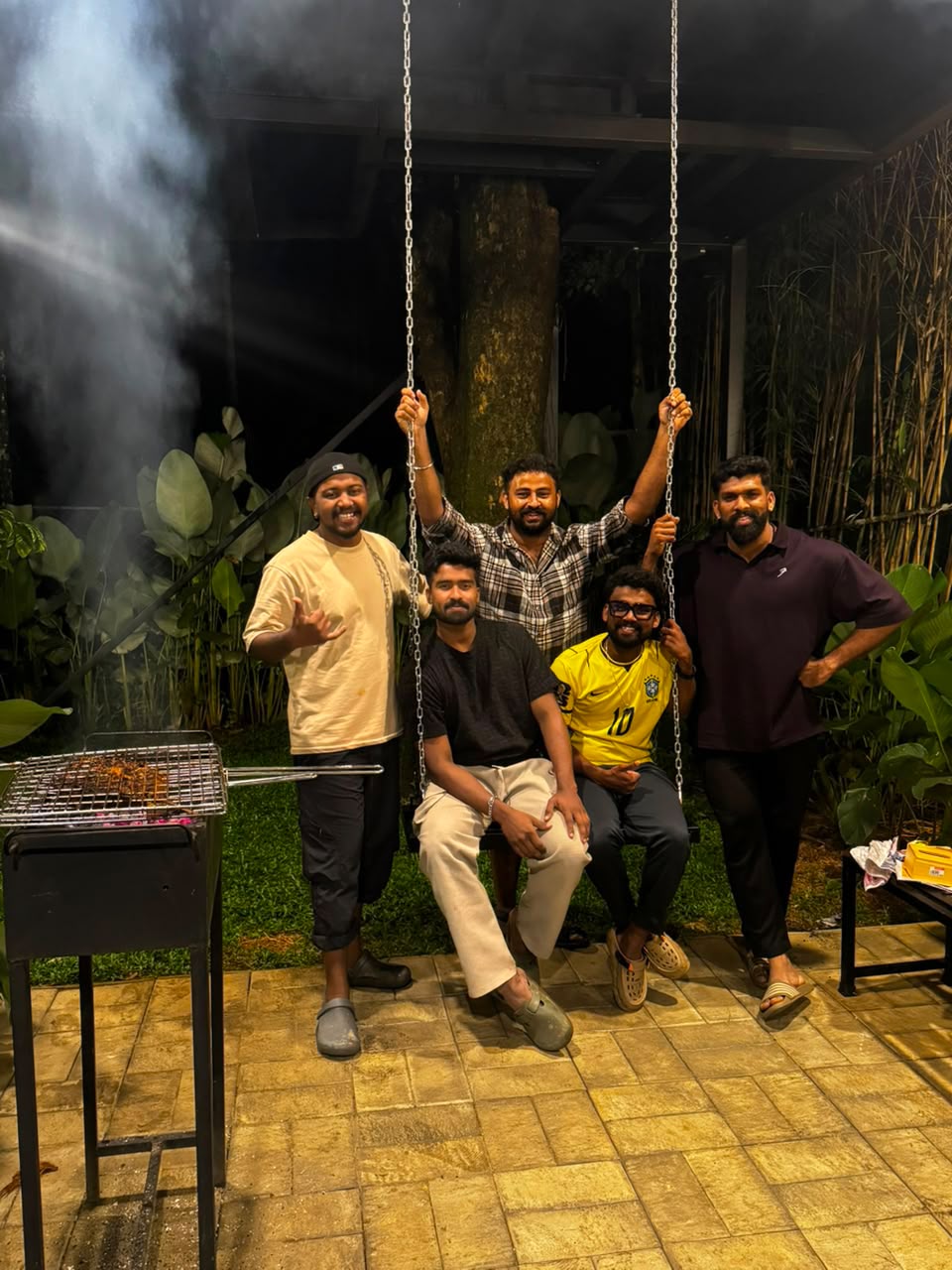 Guests enjoying a night barbecue by the garden swing